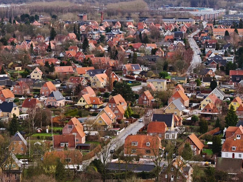 En dansk forstad med et stort antal parcelhuse og røde tegltage set fra oven