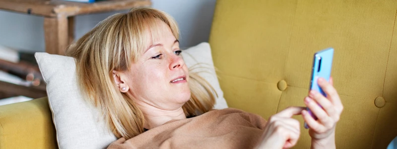 Kvinde i sofa scroller på mobil