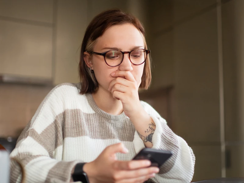 Kvinde der undrer sig over feed på mobil