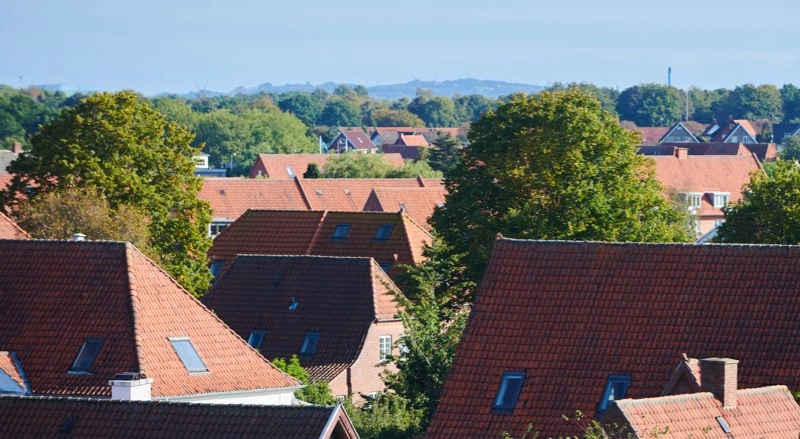 Udsigt over huse med rødt tag og grønne træer