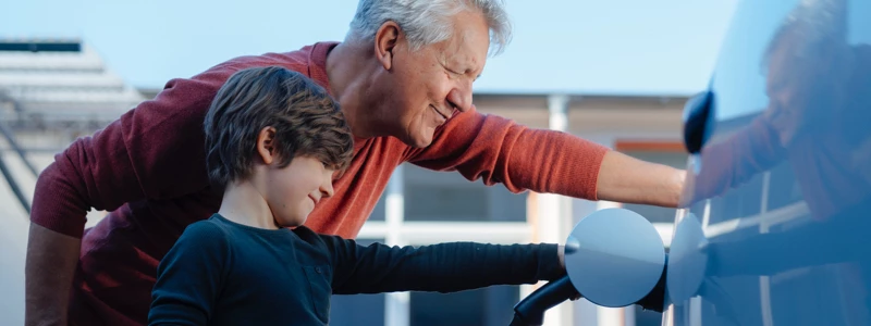 Bedstefar lærer barneban at lade elbil op