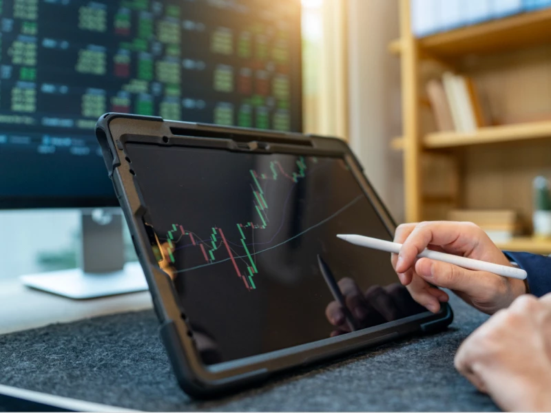 ipad og skærm der viser kursen på obligationer
