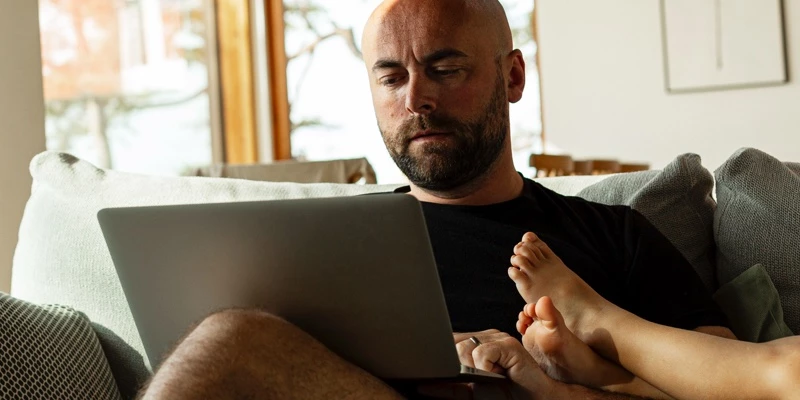 midaldrende mand sidder med computer og kigger på aktiesparekontoen