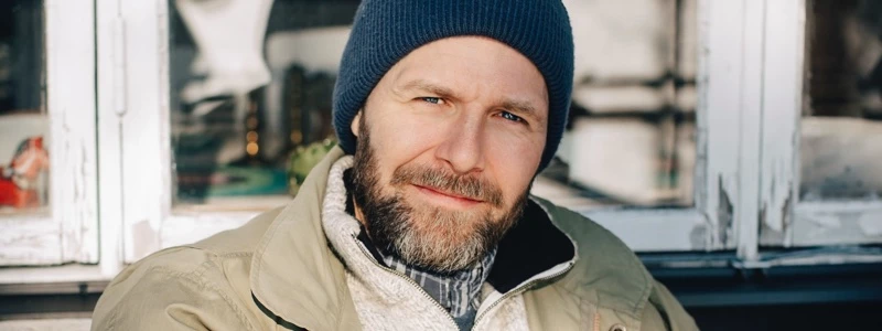 Man med hue kigger ind i kameraet