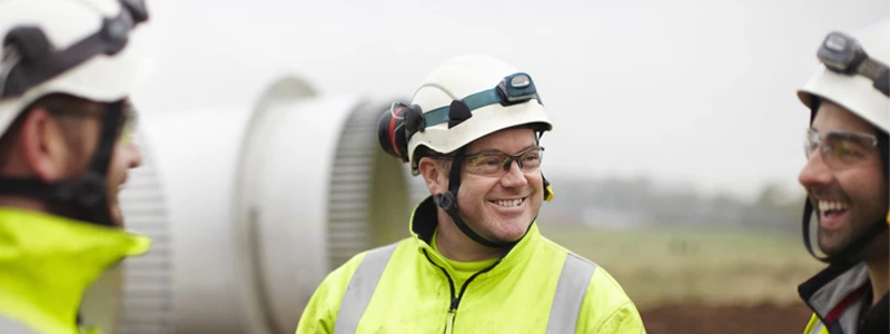 Tre konstruktionsmedarbejdere på arbejdsplads