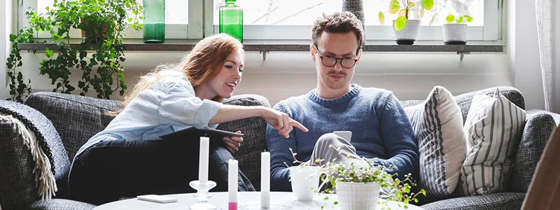 ungt par studerer årsopgørelse på mobil