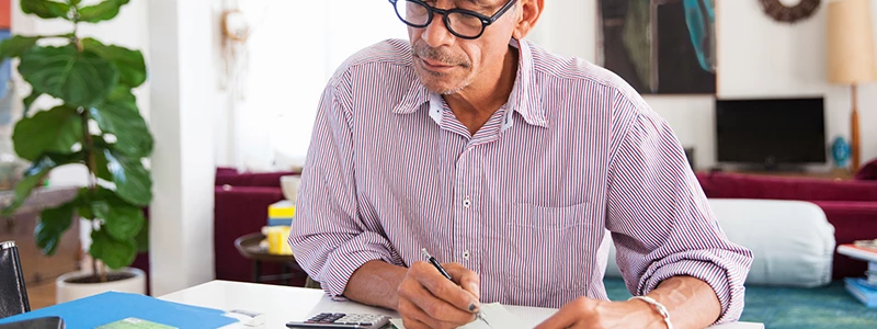 Mand med briller og skjorte i stue der undersøger virksomheders ROA