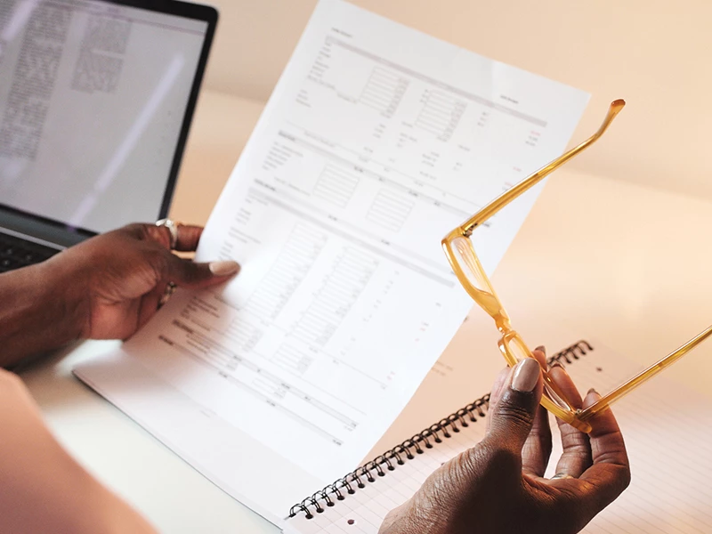 Mand der kigger på fysisk lønseddel med briller i højre hånd