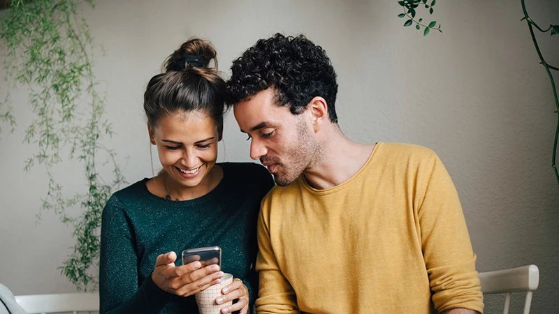 kvinde og mand der sammen kigger på en mobil