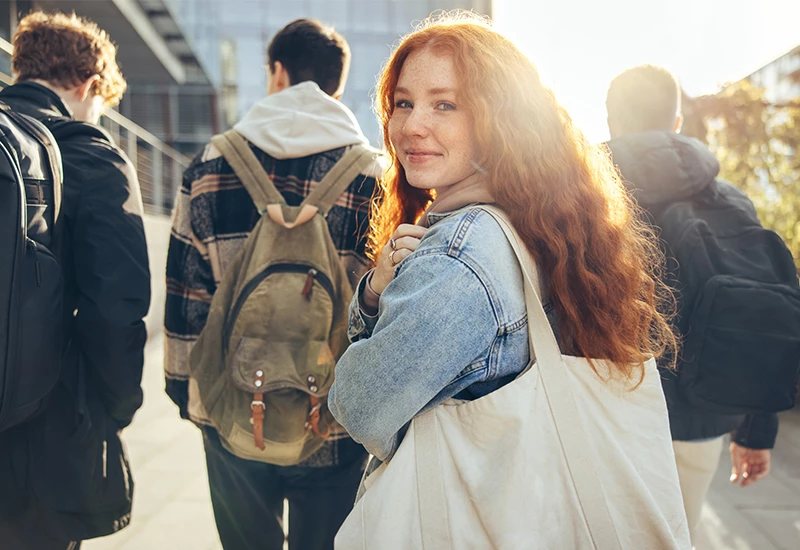 4 unge mennesker med ung rødhåret kvinde der kigger i kameraet