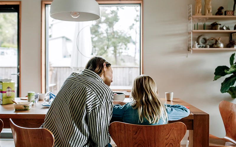 indenfor i spisestue, mor der hjælper datter med lektier