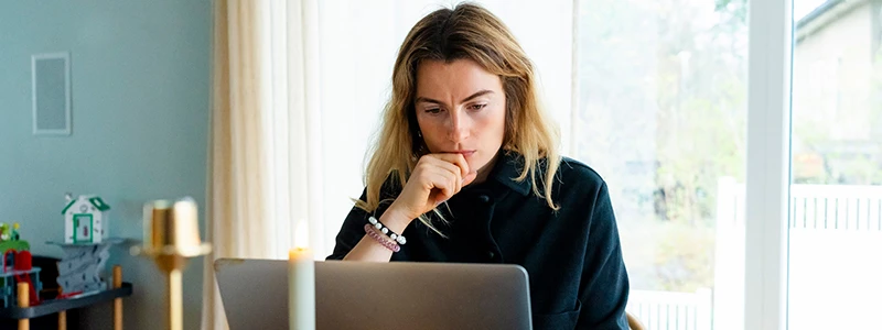 ung kvinde indenfor sidder foran sin computer