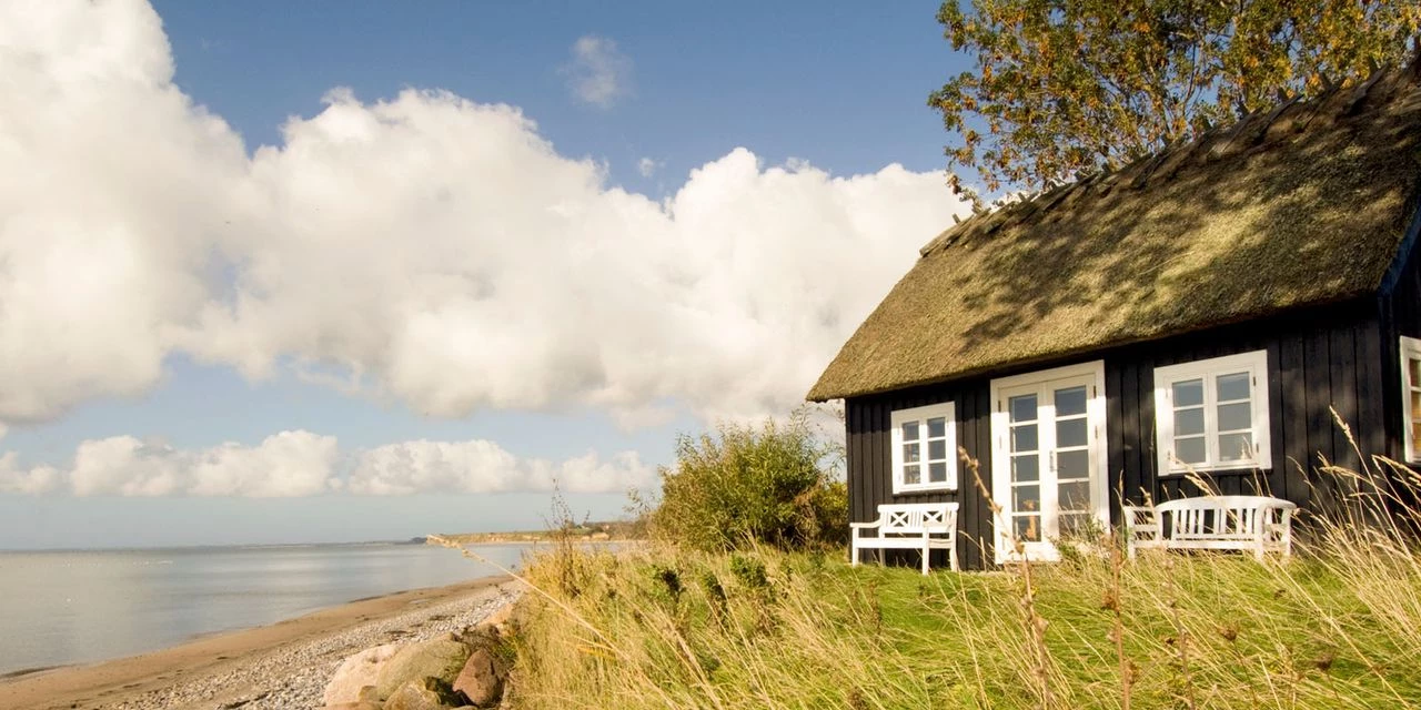 sommerhus med blå himmel og skyer i baggrund